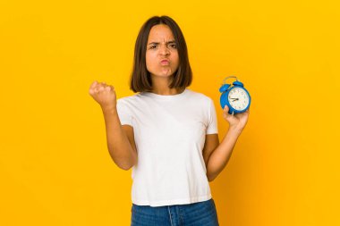 Elinde megafonla kameraya yumruk sallayan genç İspanyol kadın, agresif yüz ifadesi..