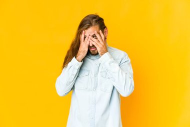 Uzun saçlı genç adam kameraya parmaklarından göz kırp, yüzünü kapatmaktan utansın..