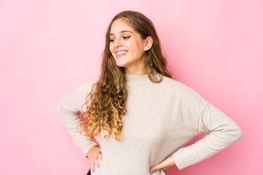 Genç beyaz kadın kendine güveniyor, ellerini kalçasında tutuyor..