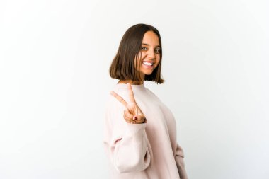 Genç melez kadın zafer işareti gösteriyor ve gülümsüyor..