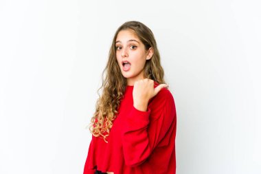 Genç beyaz kadın başparmağıyla işaret ediyor, gülüyor ve kaygısız..