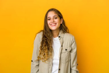 Genç beyaz kadın gülüyor ve gözlerini kapıyor, rahatlamış ve mutlu hissediyor..