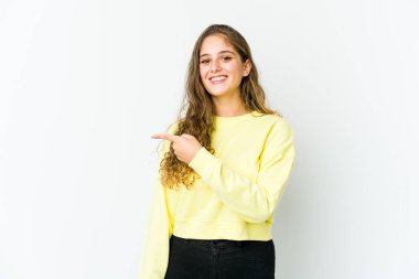 Beyaz bir kadın gülümsüyor ve boş alanda bir şeyler gösteriyor..