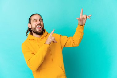 Uzun saçlı genç adam dans ediyor ve eğleniyor..