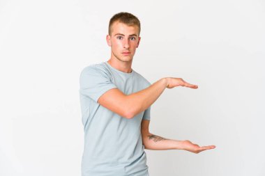 Genç, beyaz, yakışıklı bir adam ellerinin arasında bir kopya alanı tutarken şok olmuş ve hayrete düşmüştü..