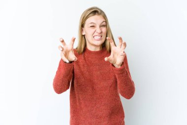 Beyaz arka planda izole edilmiş genç sarışın kadın pençelerini kedi taklidi yaparken gösteriyor, agresif bir hareket..