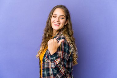 Beyaz tenli hoş bir kadın başparmağıyla işaret ediyor, gülüyor ve kaygısız..