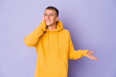 Beyaz tenli yakışıklı bir adam avucunun içinde fotokopi masası tutuyor, el üstünde tutuyor. Şaşırmış ve mutlu..