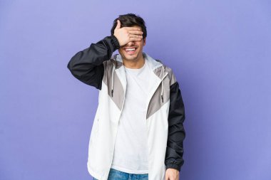 Genç, havalı adam elleriyle gözlerini kapatıyor, gülümseyerek bir sürpriz bekliyor..