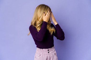 Sarışın, genç bir kadın elleriyle gözlerini kapatmaktan korkuyor..