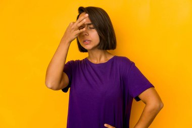 Genç İspanyol kadın sarıda izole edilmiş, başı ağrıyor, yüzüne dokunuyor..