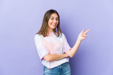 Kafkasyalı genç kadın işaret parmağıyla işaret ederek gülümsüyor..