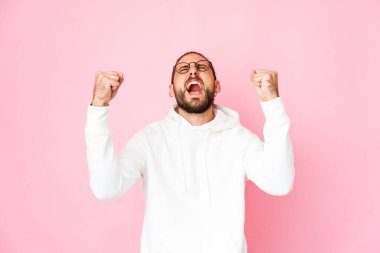 Uzun saçlı genç adam zaferden sonra yumruk kaldırıyor, kazanan konsept.