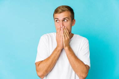 Beyaz tenli yakışıklı adam, düşünceli bir şekilde fotokopi odasına bakıyor ağzını eliyle kapatıyor..