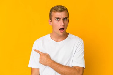 Kafkasyalı yakışıklı genç adam yan tarafı işaret ediyor.