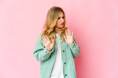 Genç, beyaz, sarışın bir kadın iğrenme hareketi gösteren birini reddediyor..