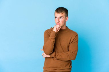 Kafkasyalı yakışıklı bir genç şüpheli ve şüpheci bir ifadeyle yana bakıyor..