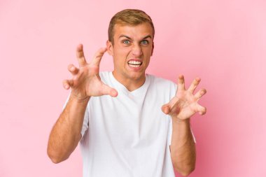 Genç, beyaz, yakışıklı bir adam pençelerini kedi taklidi yapıyor, agresif bir hareket..