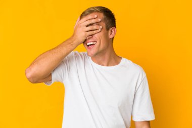 Beyaz tenli yakışıklı adam elleriyle gözlerini kapatıyor. Gülümsüyor ve bir sürpriz bekliyor..