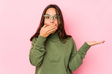 Genç, melez, İspanyol bir kadın avucunun içinde fotokopi alanı tutuyor, el üstünde tutuyor. Şaşırmış ve mutlu..