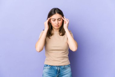 Genç beyaz kadın tapınaklara dokunuyor ve baş ağrısı çekiyor..