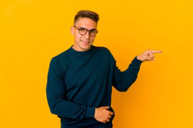 Genç, yakışıklı, beyaz tenli, izole edilmiş gülümseyen, işaret parmağıyla işaret eden adam..