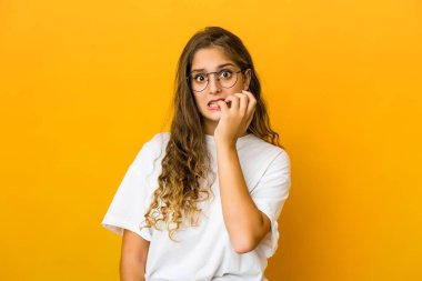 Tırnak yiyen genç beyaz kadın, gergin ve çok endişeli..