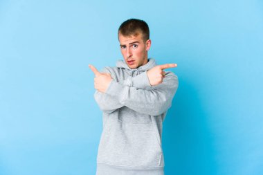 Beyaz tenli yakışıklı adam iki seçenek arasında seçim yapmaya çalışıyor..