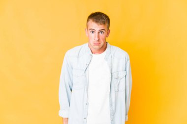 Genç beyaz yakışıklı adam omuz silker ve gözleri açık kalır..