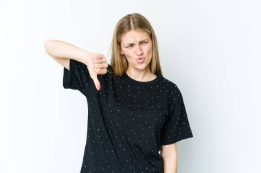 Beyaz arka planda izole edilmiş genç sarışın kadın baş parmağını aşağı gösteriyor ve hoşlanmadığını ifade ediyor..