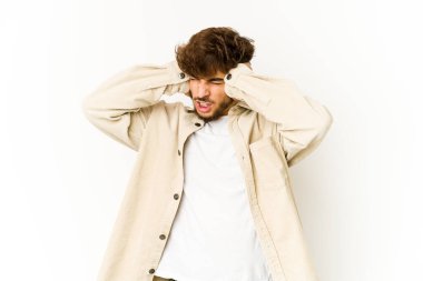 Beyaz arka planda genç bir Arap. Kulakları elleriyle kapatıyor..