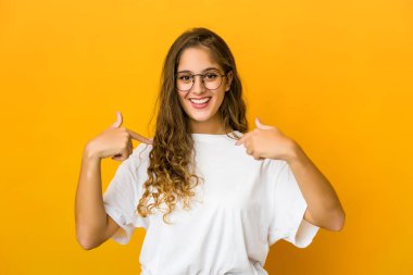 Kafkasyalı genç bir kadın parmağını gösterip, gülümseyerek şaşırdı..