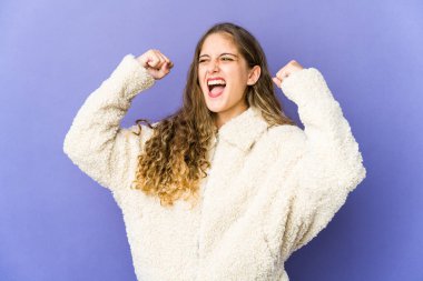 Genç, beyaz, tatlı bir kadın zaferden sonra yumruğunu kaldırıyor, kazanan konsept.