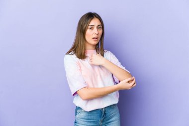 Genç beyaz kadın dirsek masajı yapıyor, kötü bir hareketin ardından acı çekiyor..