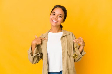 Elinde cep saati tutan genç İspanyol kadın gömlek fotokopi odasını elle işaret ediyor, gururlu ve kendinden emin.