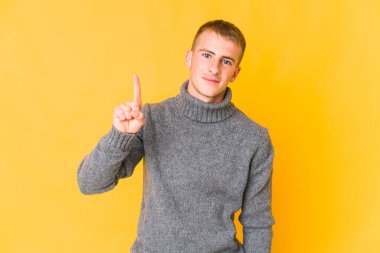 Genç, beyaz, yakışıklı bir numara parmağıyla görünüyor..