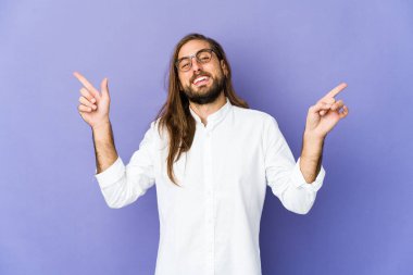 Uzun saçlı genç adam farklı fotokopi alanlarını işaret ediyor, birini seçiyor, parmaklarıyla gösteriyor..