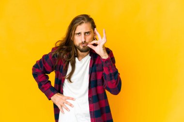 Uzun saçlı genç adam dudaklarında parmaklarıyla bir sır saklıyor..