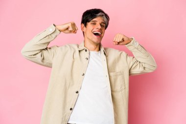 Genç, sıska İspanyol adam güç simgesi olan kollarıyla güç gösterisi yapıyor.