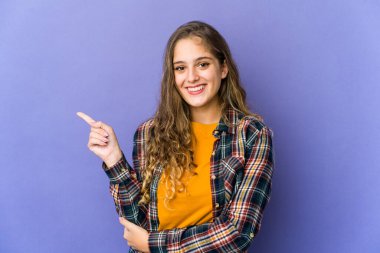 Beyaz tenli hoş bir kadın işaret parmağıyla işaret ederek gülümsüyor..
