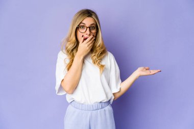 Beyaz tenli sarışın bir kadın avucunun içinde fotokopi masası tutuyor, el üstünde tutuyor. Şaşırmış ve mutlu..