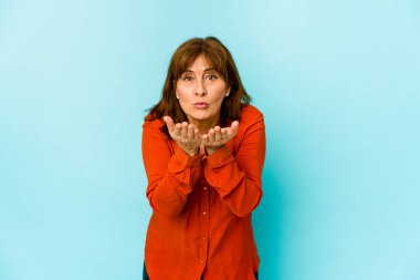 Üst düzey beyaz kadın, dudaklarını katlayıp, avuç içleriyle hava öpücüğü yolluyor..