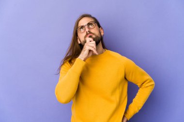 Uzun saçlı genç adam rahatlamış görünüyor. Bir şeyin fotokopi odasına baktığını düşünüyor..