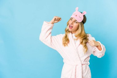 Genç sarışın, beyaz kadın pijama giyiyor. Zaferden sonra yumruğunu kaldırıyor..