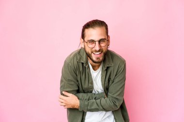 Uzun saçlı genç adam gülüyor ve eğleniyor..