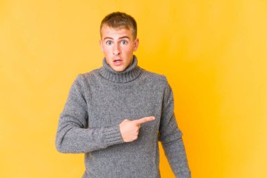 Kafkasyalı yakışıklı genç adam yan tarafı işaret ediyor.