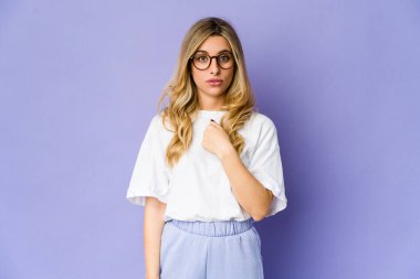 Genç, beyaz, sarışın kadın şaşırdı. Parmakla işaret etti, gülümsedi..