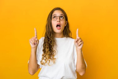 Kafkasyalı genç bir kadın ağzı açık bir şekilde üst tarafı işaret ediyor..