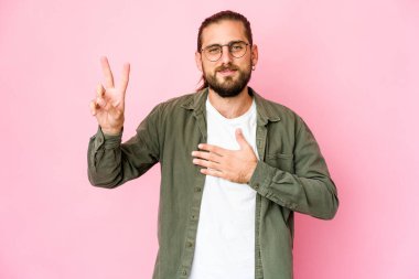 Uzun saçlı genç adam yemin ediyor, elini göğsüne koyuyor..