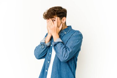 Beyaz arka planda genç bir Arap parmaklarıyla gözünü kırp korkmuş ve gergin..